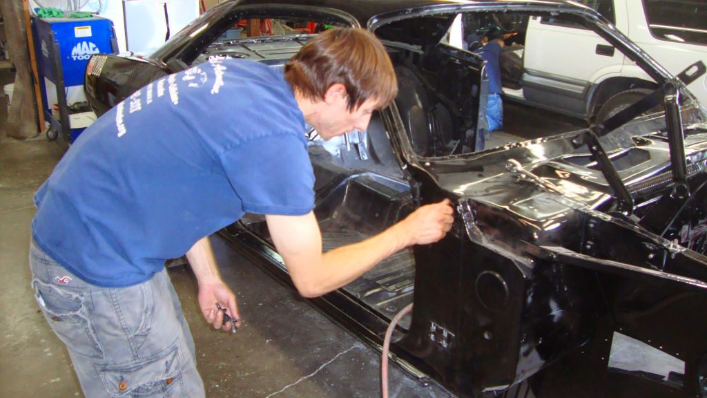 Photo of a 1970 Plymouth AAR Cuda being reassembled after paint and body work